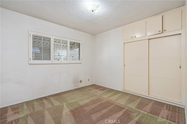 unfurnished bedroom featuring light carpet, a closet, and a textured ceiling