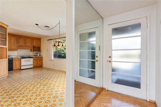 kitchen featuring decorative light fixtures, backsplash, light parquet floors, black dishwasher, and white range oven