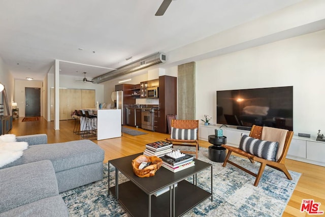 living room featuring ceiling fan and light hardwood / wood-style flooring