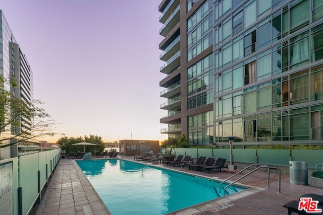 pool at dusk with a patio