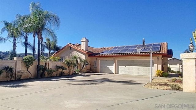 view of front of property with solar panels and a garage