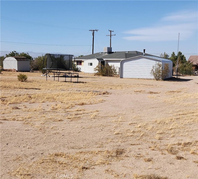 view of yard featuring central AC unit and a trampoline