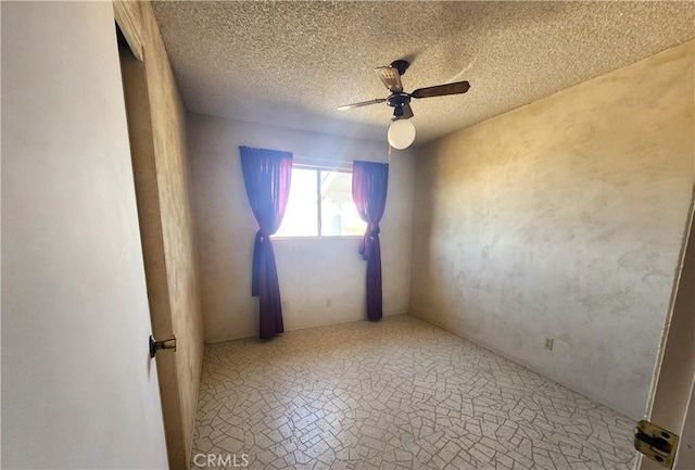 empty room with ceiling fan and a textured ceiling