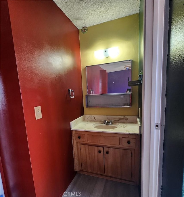 bathroom with vanity, a textured ceiling, and hardwood / wood-style floors