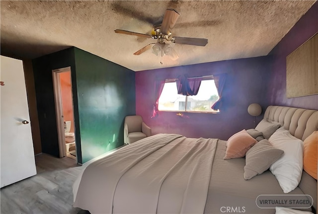 bedroom featuring ceiling fan, a textured ceiling, ensuite bath, and light wood-type flooring