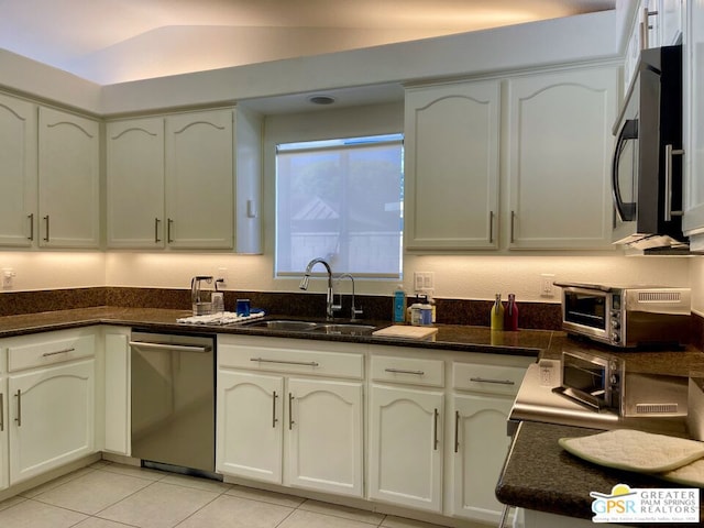 kitchen featuring sink, white cabinets, light tile patterned floors, and dishwasher