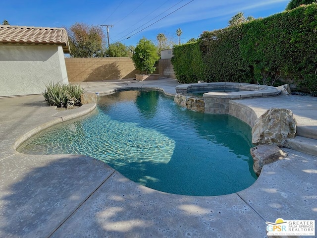 view of pool with an in ground hot tub