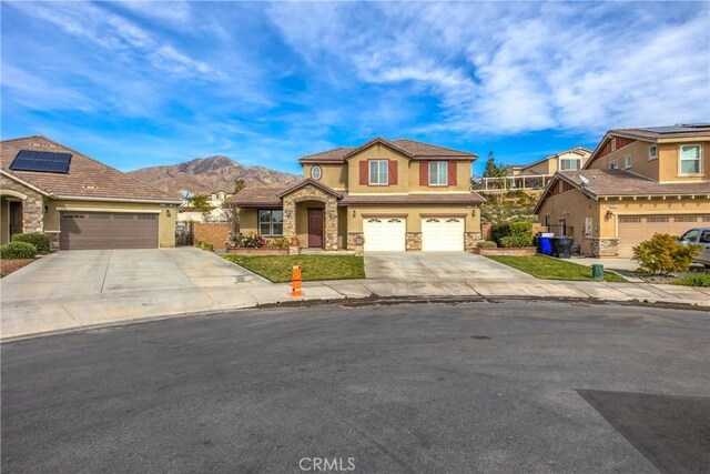 front of property with a garage and a mountain view