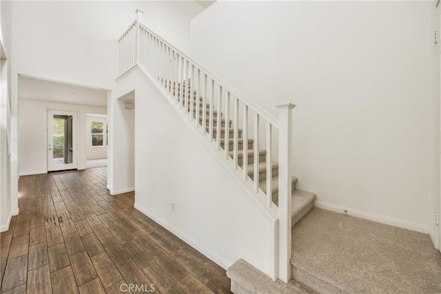 stairway featuring hardwood / wood-style flooring and a high ceiling