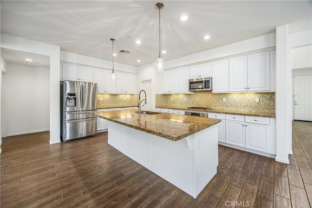 kitchen featuring sink, white cabinetry, hanging light fixtures, a center island with sink, and appliances with stainless steel finishes