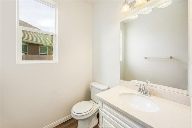 bathroom with vanity, toilet, hardwood / wood-style floors, and a wealth of natural light