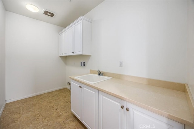 washroom with cabinets, hookup for a washing machine, and sink