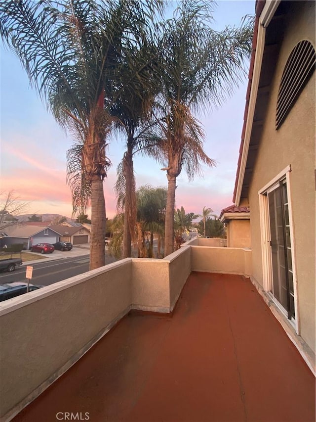 patio terrace at dusk featuring a balcony