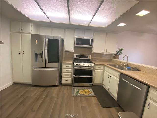 kitchen with stainless steel appliances, dark hardwood / wood-style flooring, sink, and white cabinets