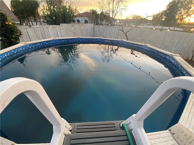 view of pool at dusk