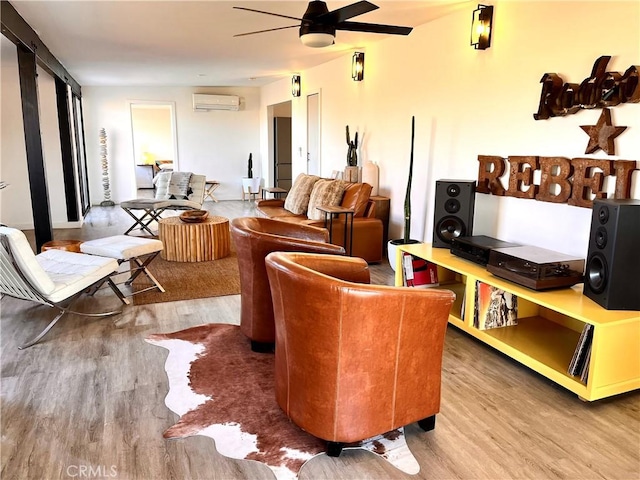 living room featuring an AC wall unit, hardwood / wood-style flooring, and ceiling fan