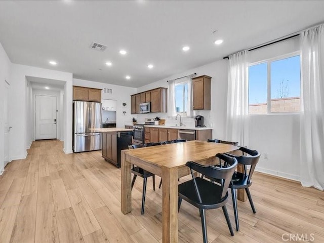 dining space featuring sink and light hardwood / wood-style flooring