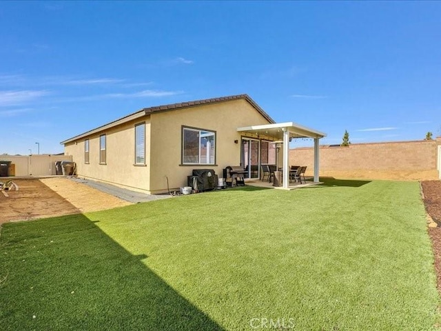 back of property with a patio area and a lawn