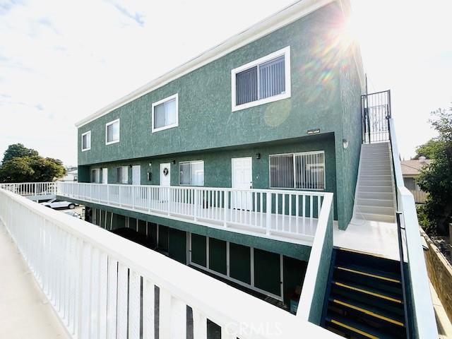 back of property with stairs and stucco siding