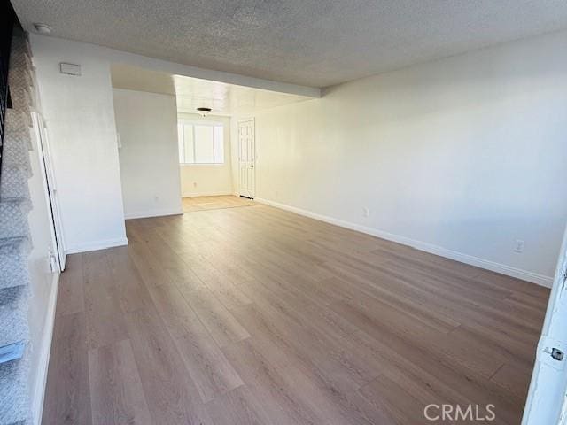 spare room featuring a textured ceiling and hardwood / wood-style flooring