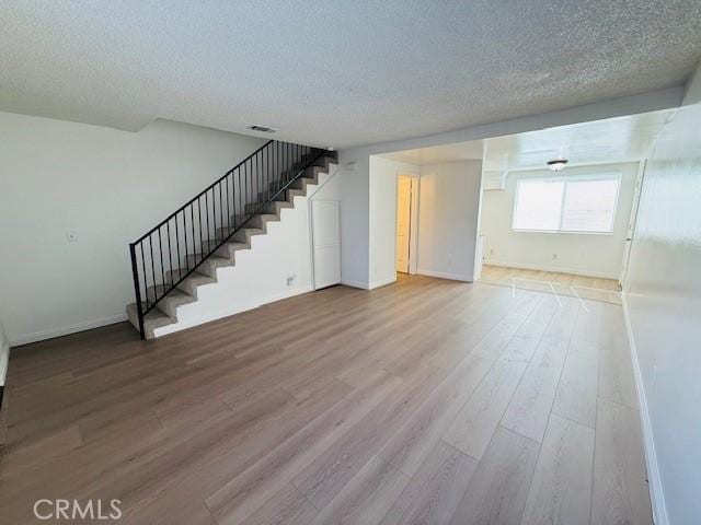 interior space with a textured ceiling and hardwood / wood-style flooring