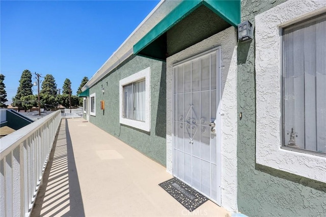 doorway to property featuring stucco siding