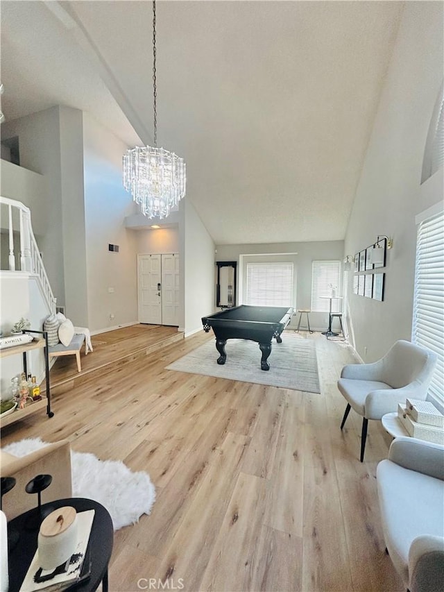 recreation room featuring high vaulted ceiling, pool table, a notable chandelier, and light wood-type flooring