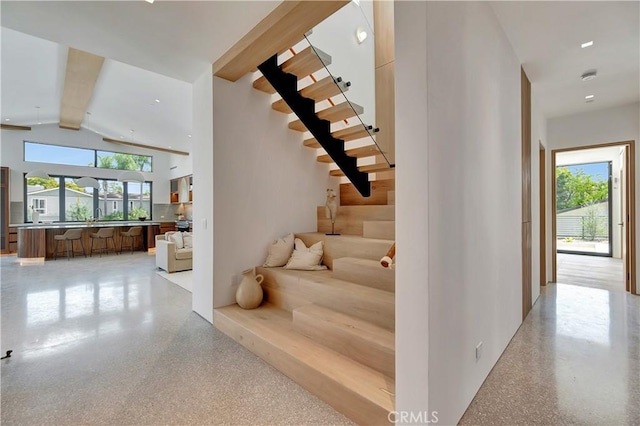 stairs featuring vaulted ceiling with beams