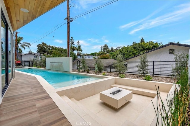 view of pool featuring pool water feature, a patio area, and a fire pit