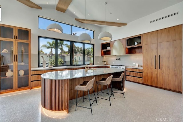 bar featuring pendant lighting, beamed ceiling, tasteful backsplash, sink, and light stone counters