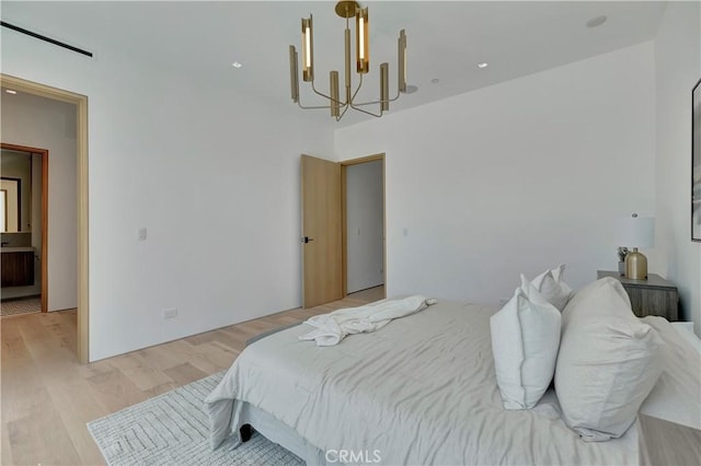 bedroom with light wood-type flooring and a chandelier