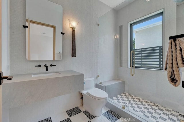 bathroom featuring toilet, an enclosed shower, and sink