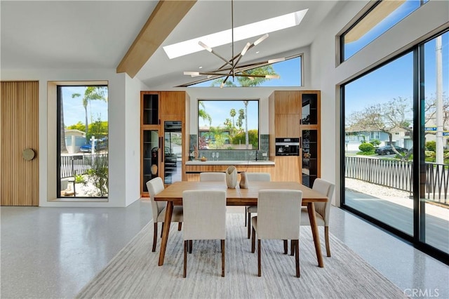 dining area with vaulted ceiling with skylight and a chandelier