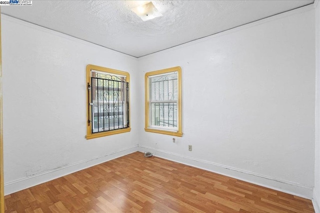 spare room featuring hardwood / wood-style flooring and a textured ceiling