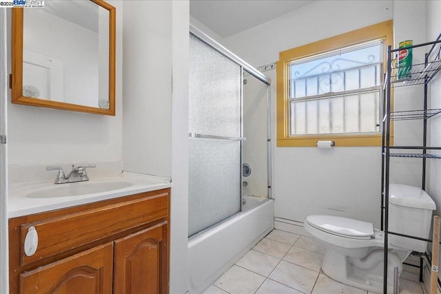 full bathroom with combined bath / shower with glass door, vanity, toilet, and tile patterned flooring