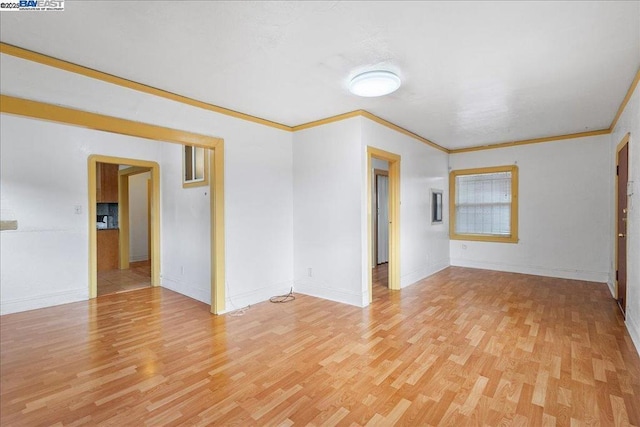 unfurnished room featuring light hardwood / wood-style floors and crown molding