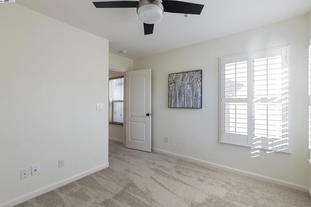 carpeted empty room featuring ceiling fan