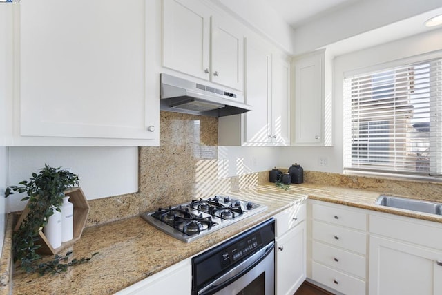 kitchen with sink, white cabinetry, stainless steel appliances, tasteful backsplash, and light stone countertops