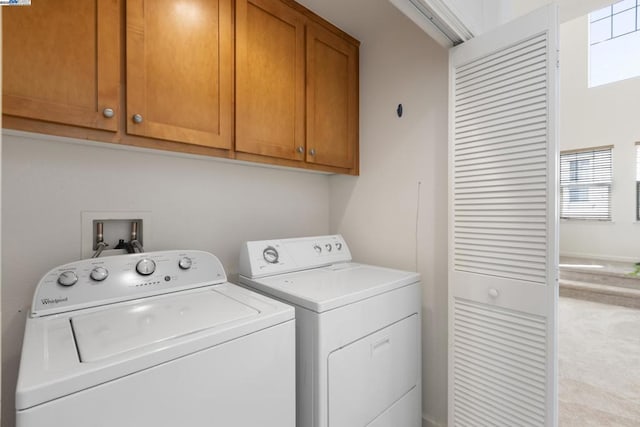 clothes washing area featuring independent washer and dryer and cabinets