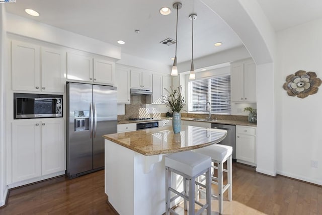 kitchen featuring a kitchen island, white cabinetry, sink, hanging light fixtures, and stainless steel appliances