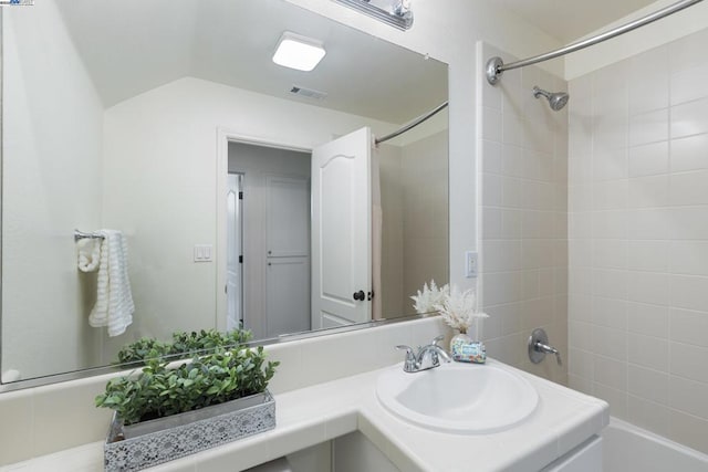 bathroom with tiled shower / bath combo and sink