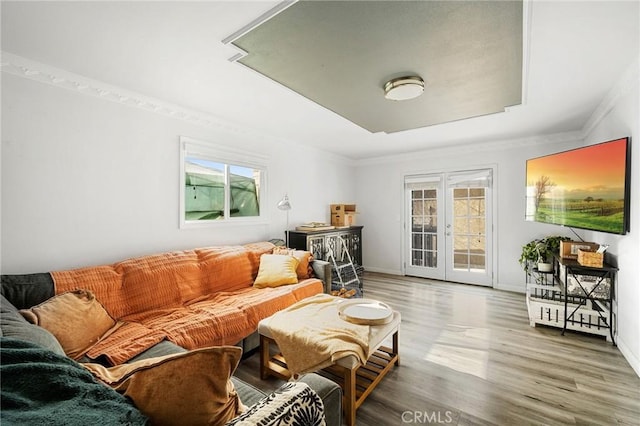 living room featuring a wealth of natural light, french doors, baseboards, and wood finished floors