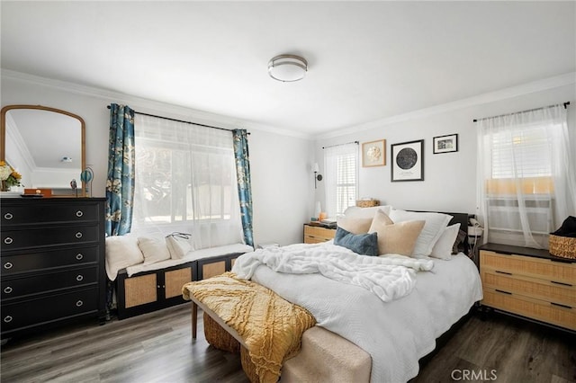 bedroom with ornamental molding and wood finished floors