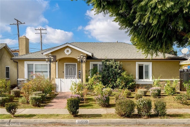 ranch-style home featuring fence, a chimney, and stucco siding