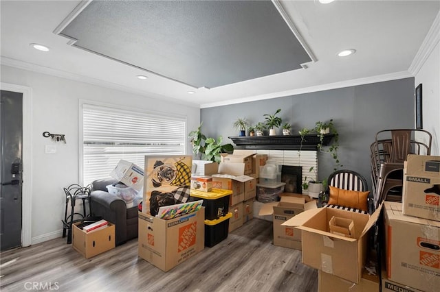 interior space featuring recessed lighting, ornamental molding, a fireplace, and wood finished floors