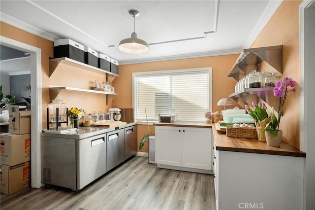 kitchen with light wood finished floors, wood counters, crown molding, and open shelves