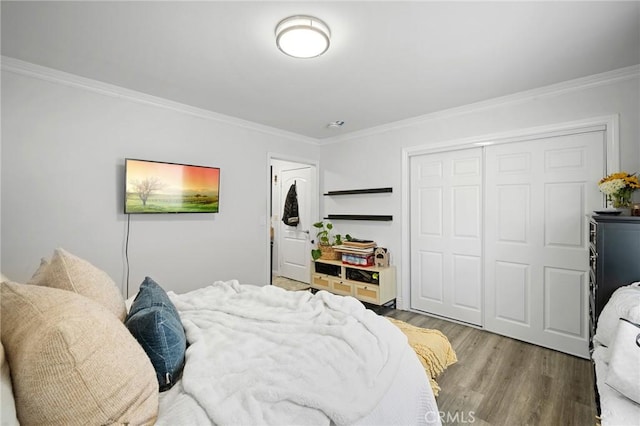 bedroom featuring crown molding, wood finished floors, and a closet