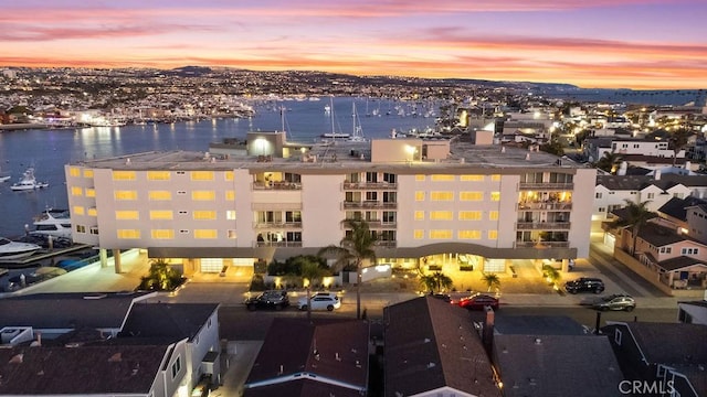 aerial view at dusk featuring a water view