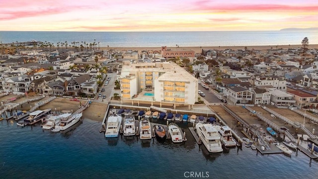 aerial view at dusk featuring a water view