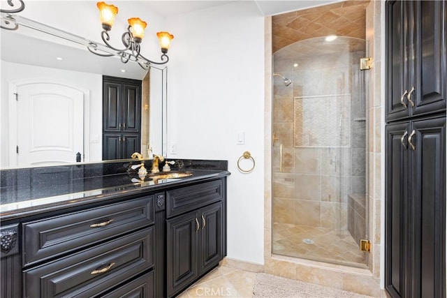 bathroom featuring vanity, a chandelier, tile patterned floors, and walk in shower